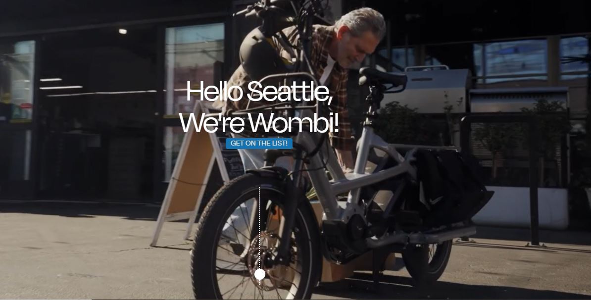 Wombi man and bike in front of store Wombi expands e-bike subscription service